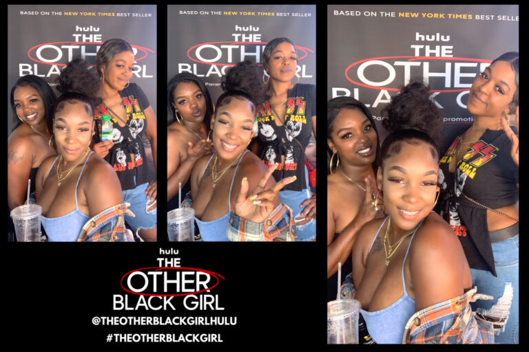 Three women posing for a digital photo at the other black girl at a photo booth in Los Angeles.